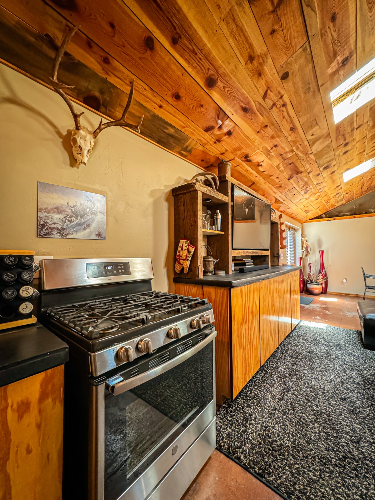 Kitchen with gas range, antlers, juniper ceiling