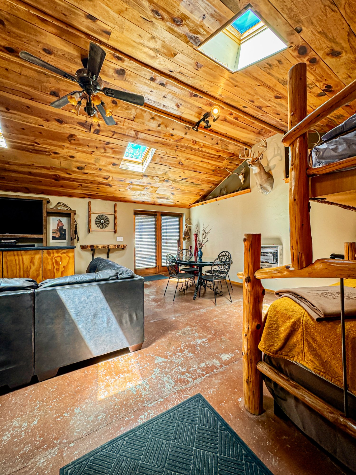 Main room from opposite angle — dining, bunk beds, skylights