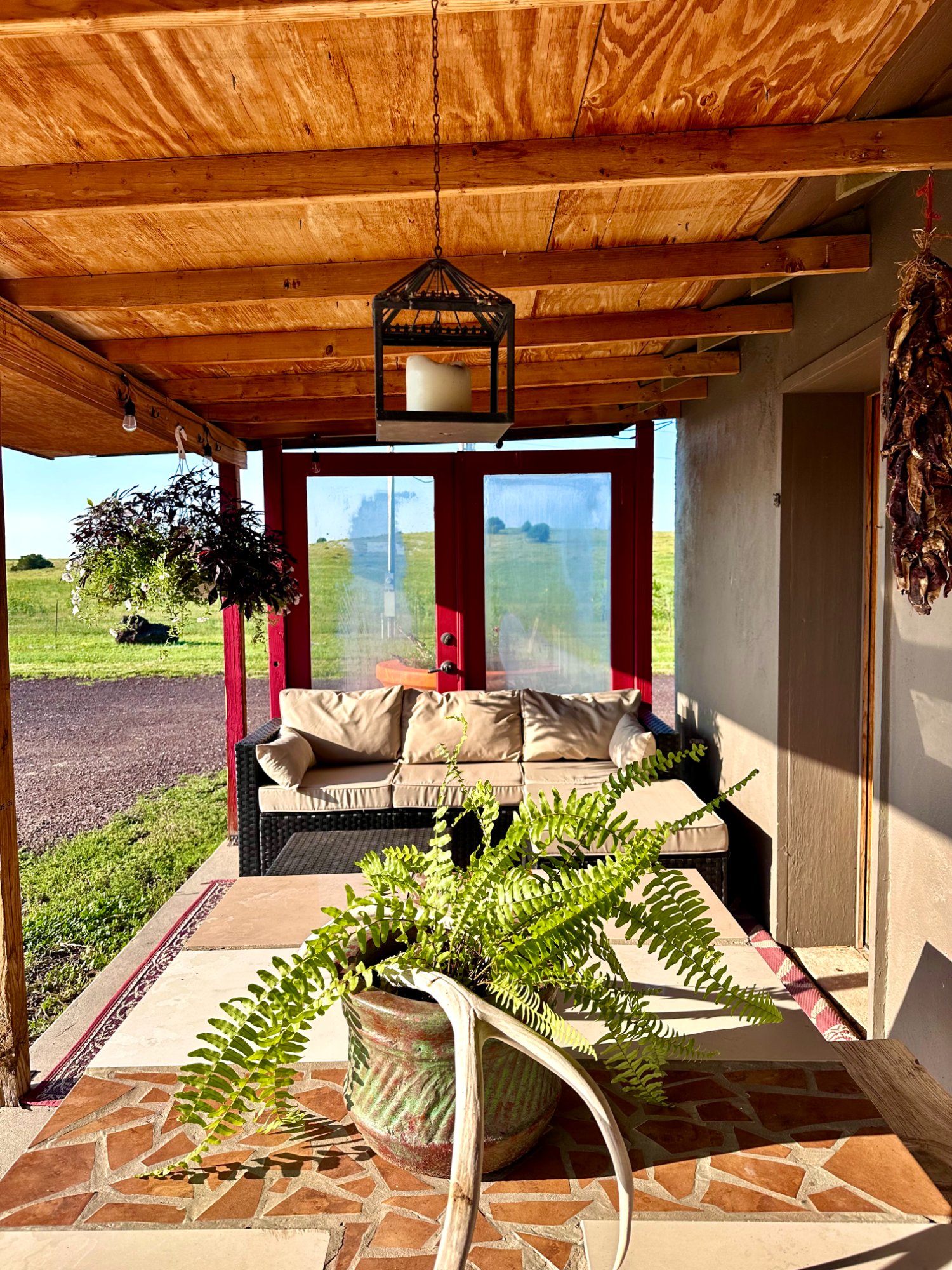 Covered porch alternate angle with lantern and fern