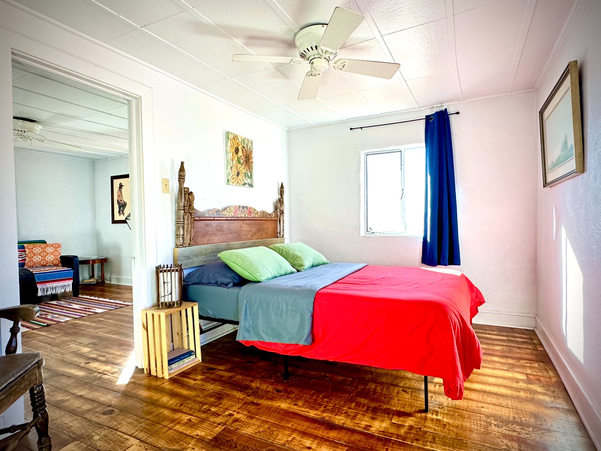Bedroom with carved headboard and wide plank floors