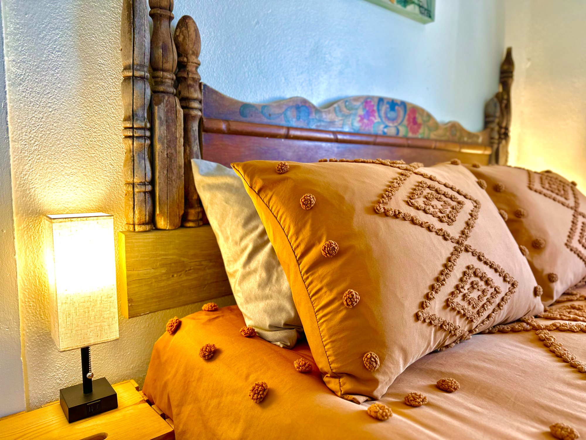 Bedroom close detail, carved headboard, mustard bedding