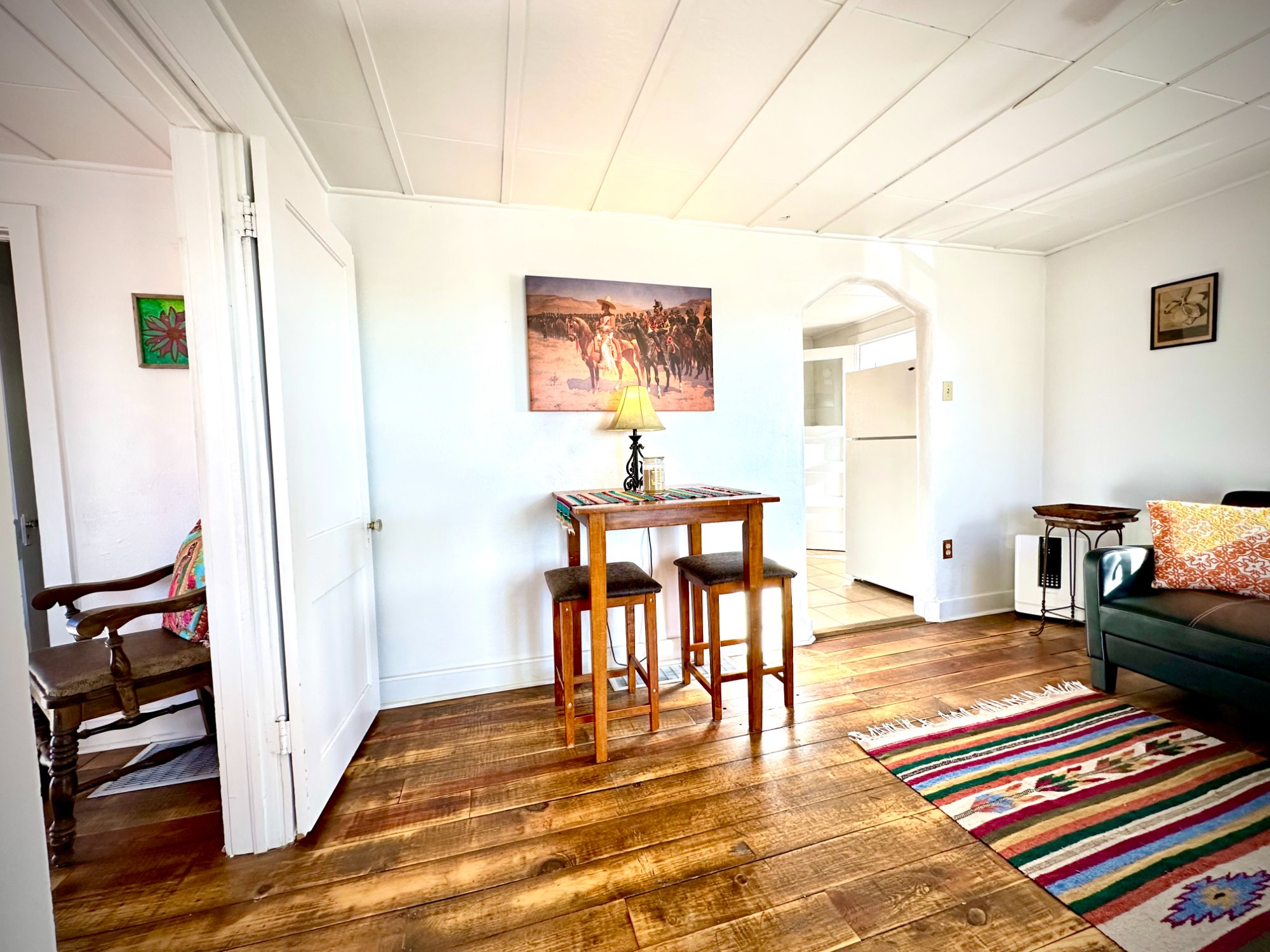 Living room with arched doorway and wide plank floors