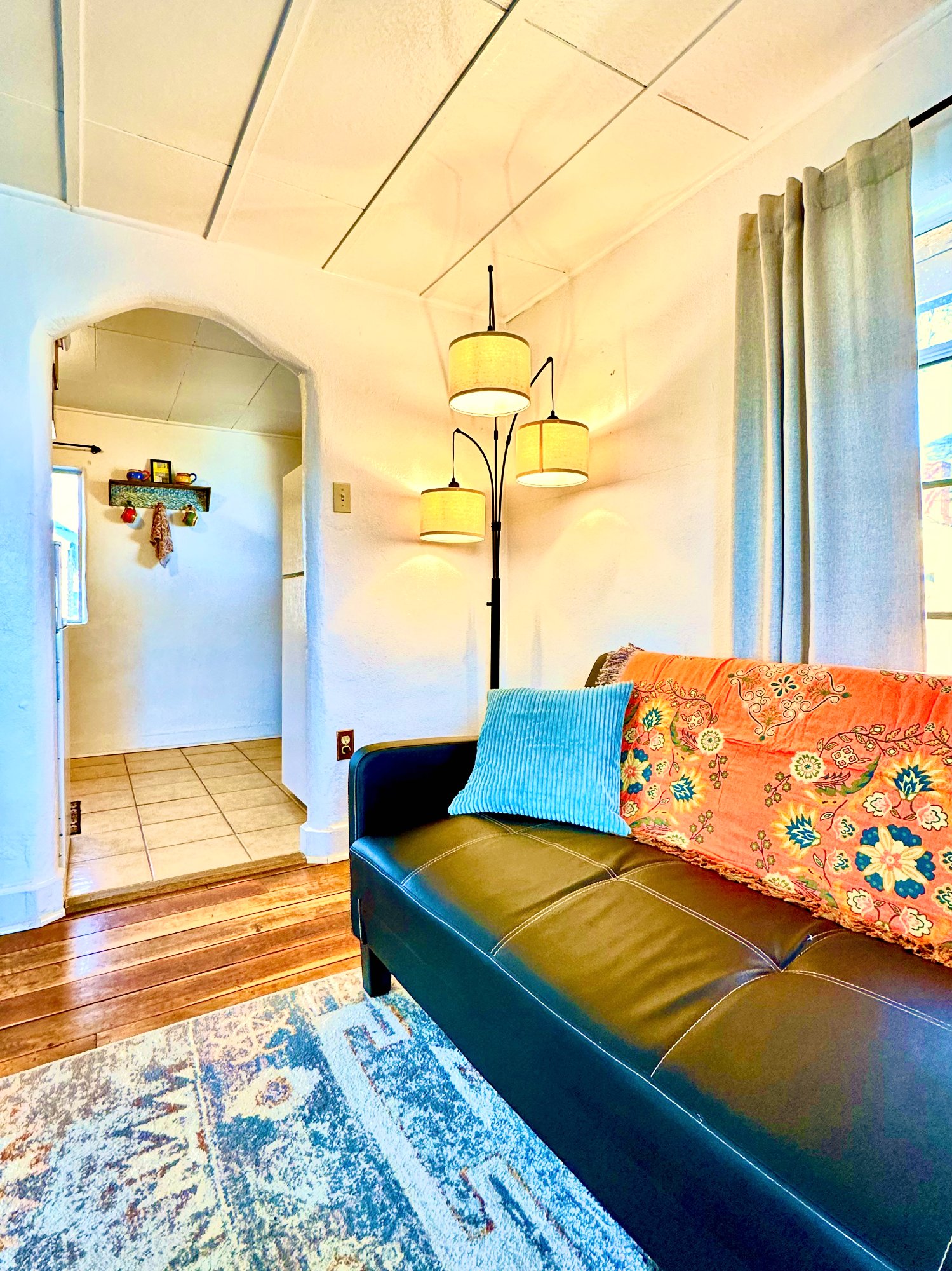 Living room with sofa and arched doorway leading to kitchen