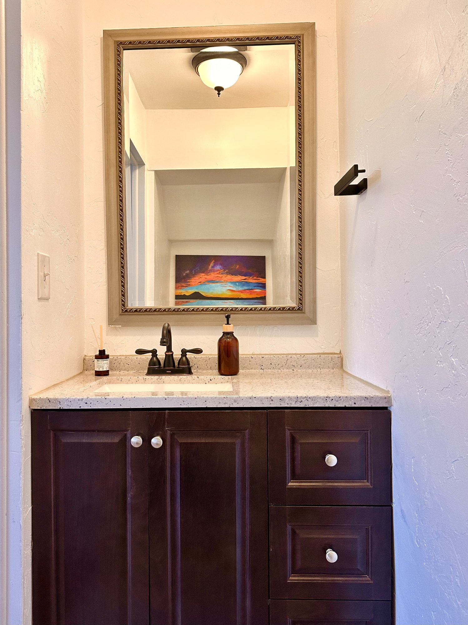 Bathroom with Capulin sunset painting reflected in mirror