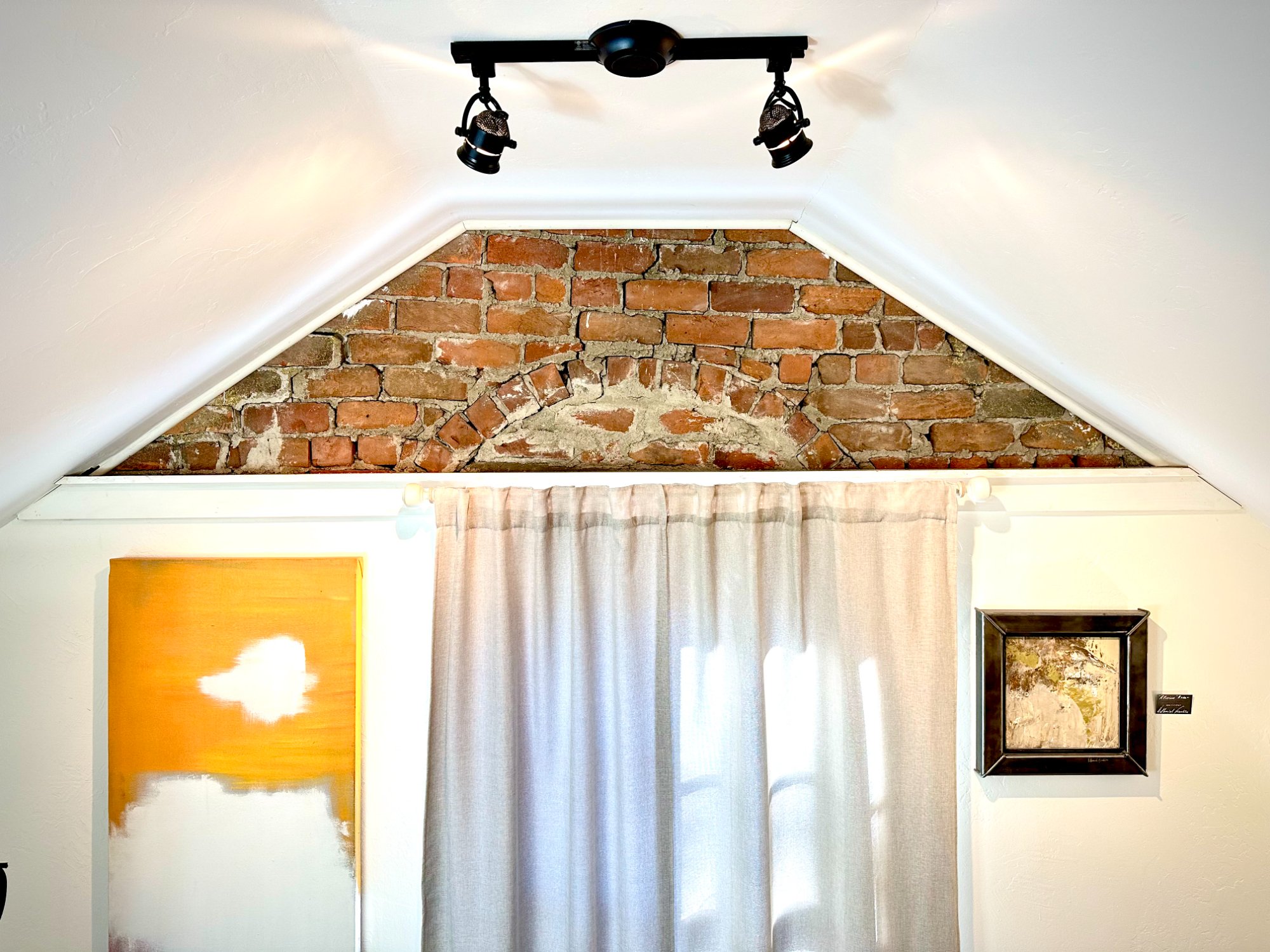 Exposed brick gable with art on either side