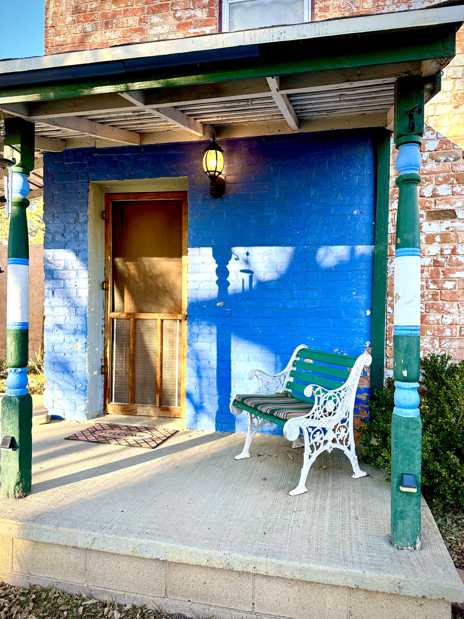 Front porch with blue door and green columns