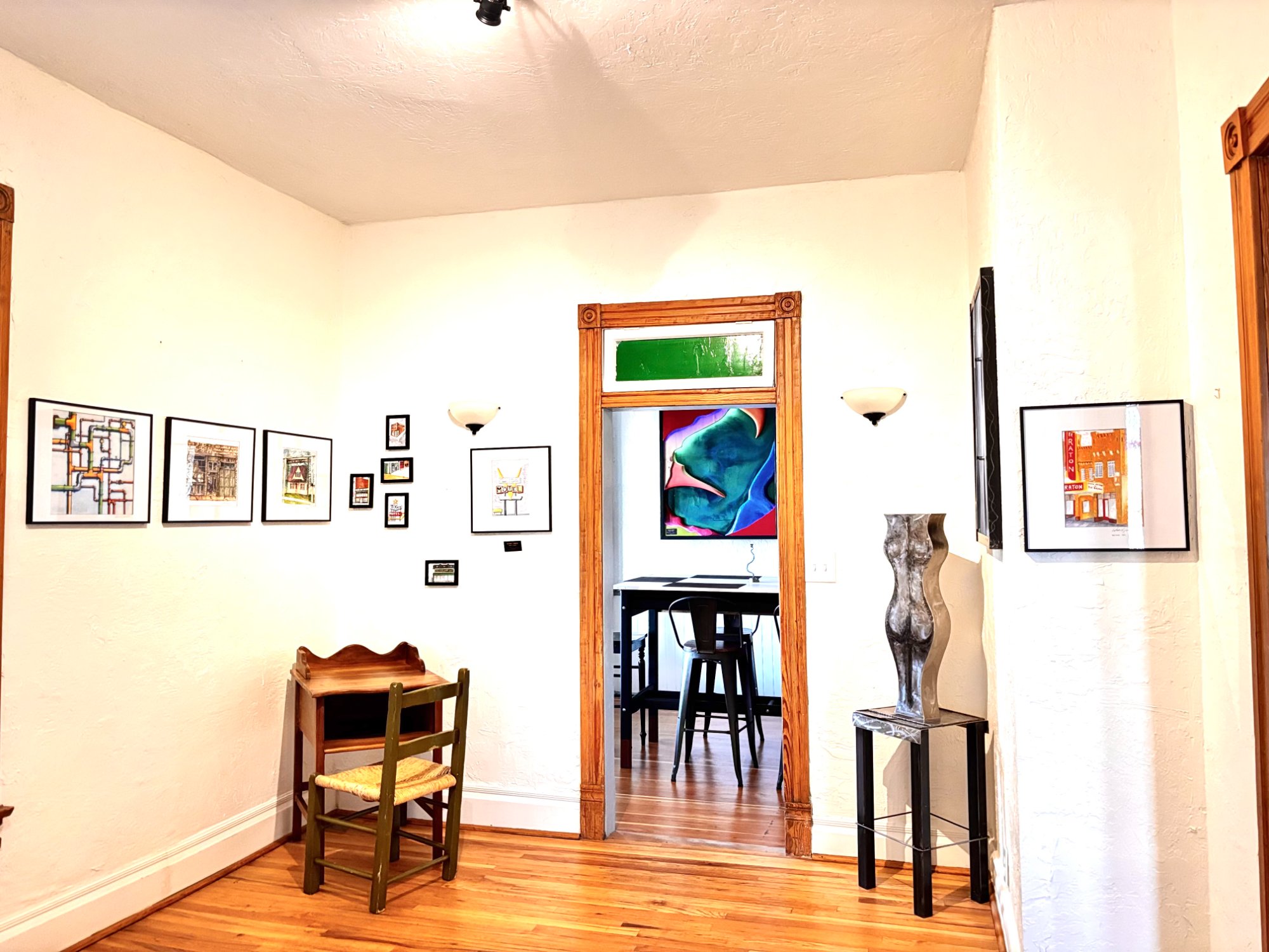 Gallery wall with watercolor prints and sculpture
