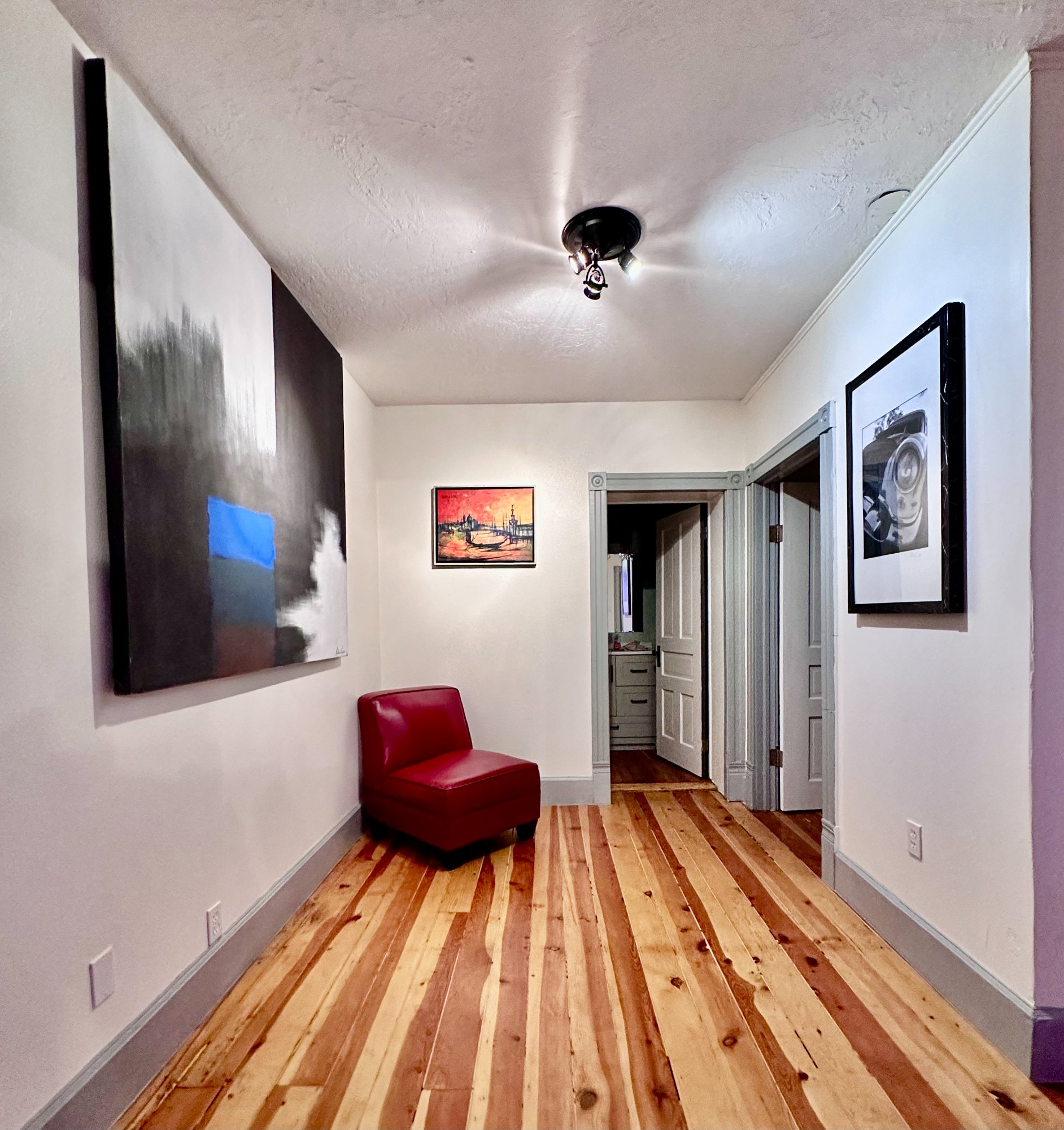 Hallway gallery with large dark painting