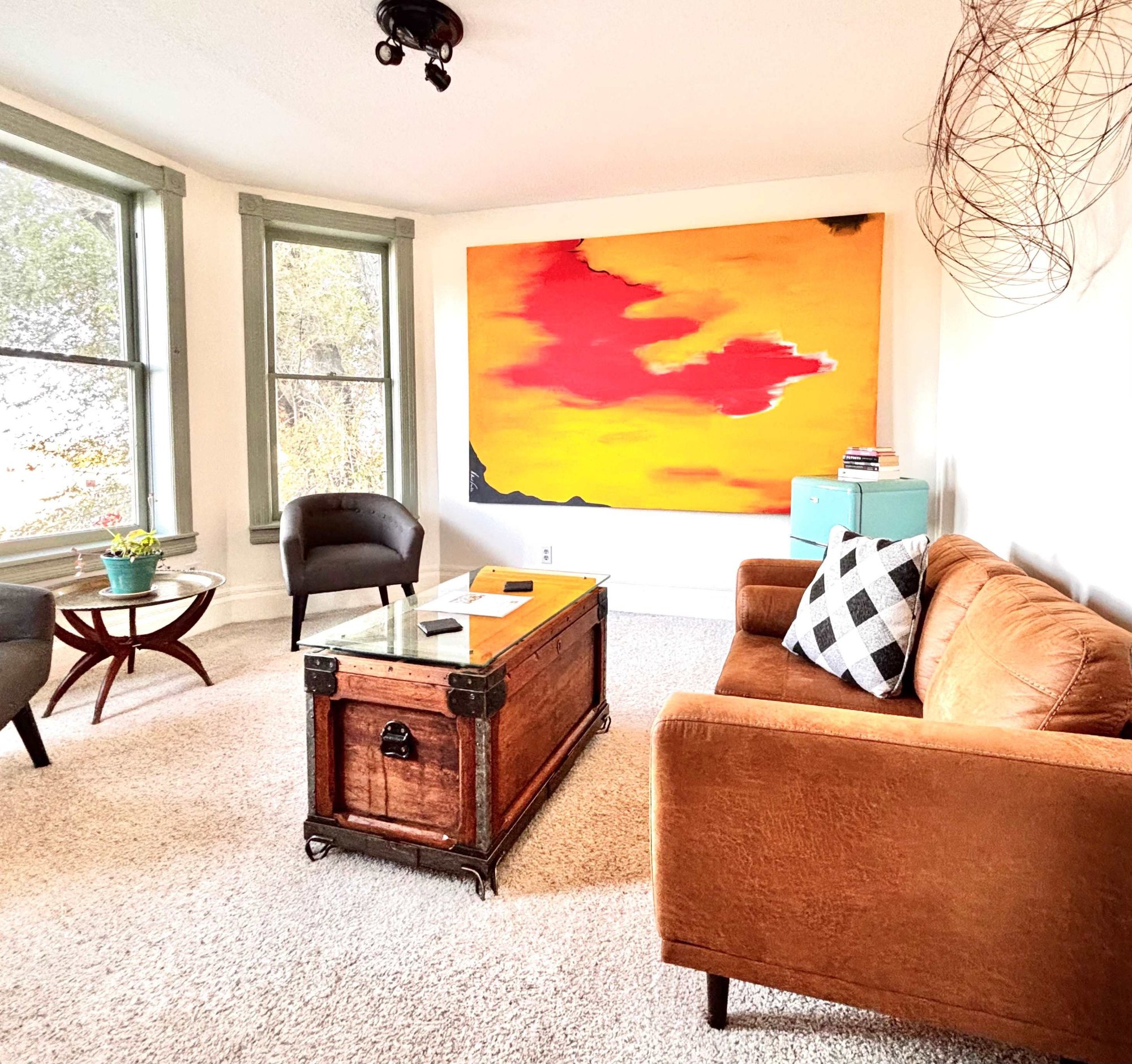 Living room with original paintings and bay windows